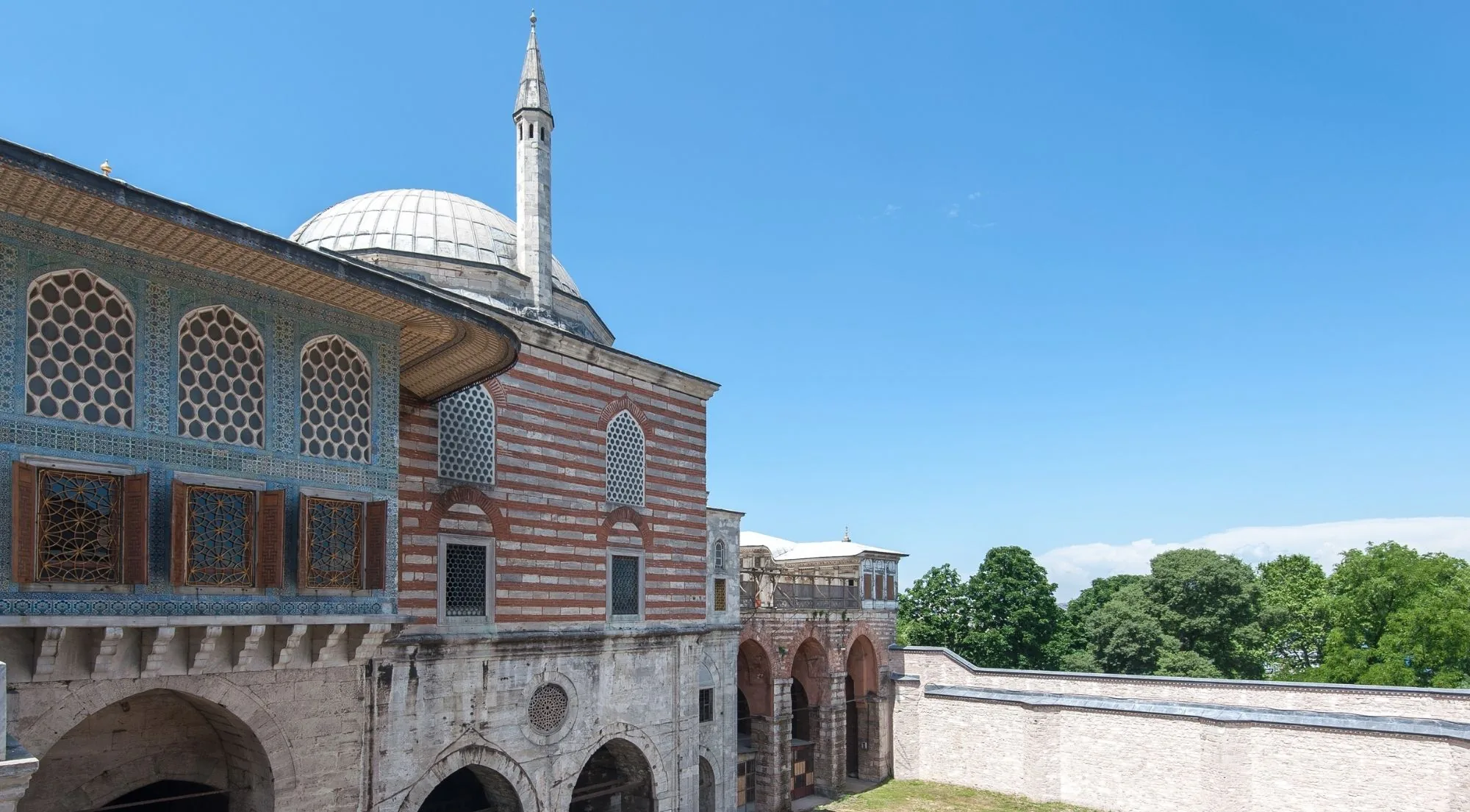 The tiled facade and lead dome of the Library of Ahmed III in the Third Court of Topkapi Palace against a clear blue sky