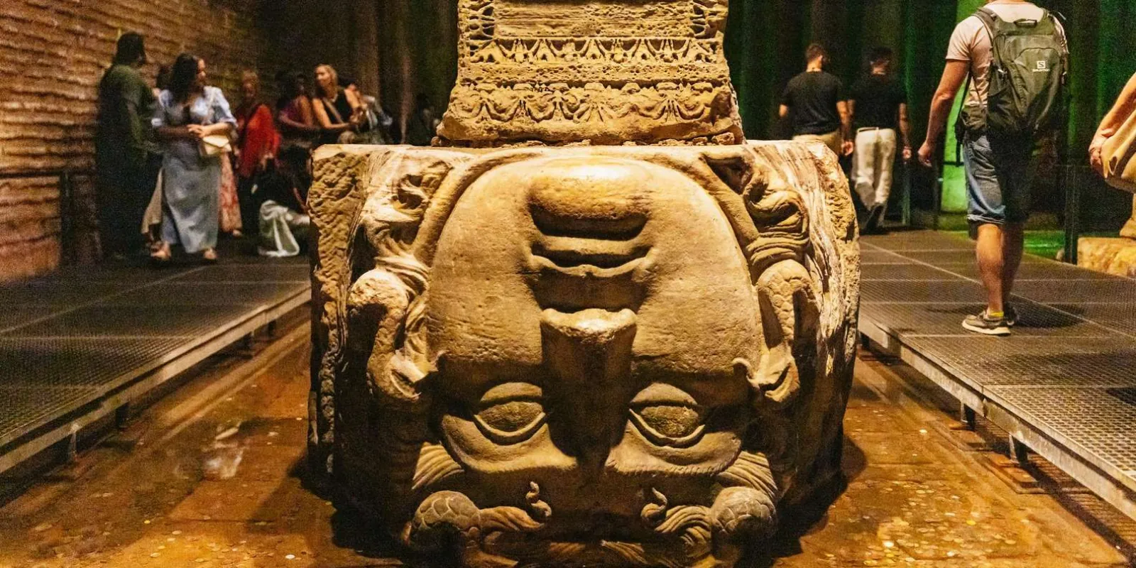 The carved Medusa head column base standing in the shallow water of the Basilica Cistern