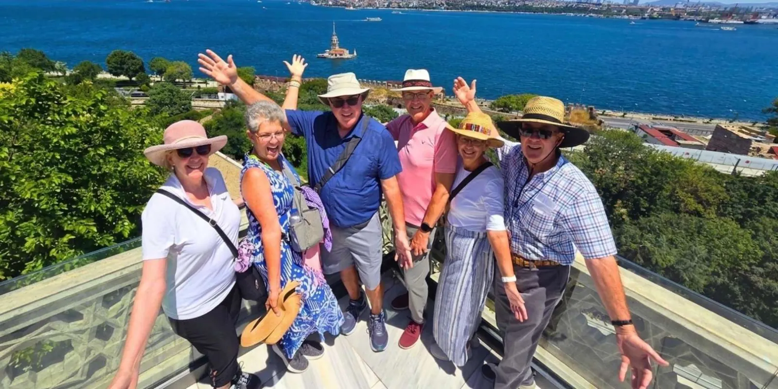 A small private group on the glass-floored viewing terrace at Topkapi Palace, with the Maiden's Tower and the Bosphorus behind