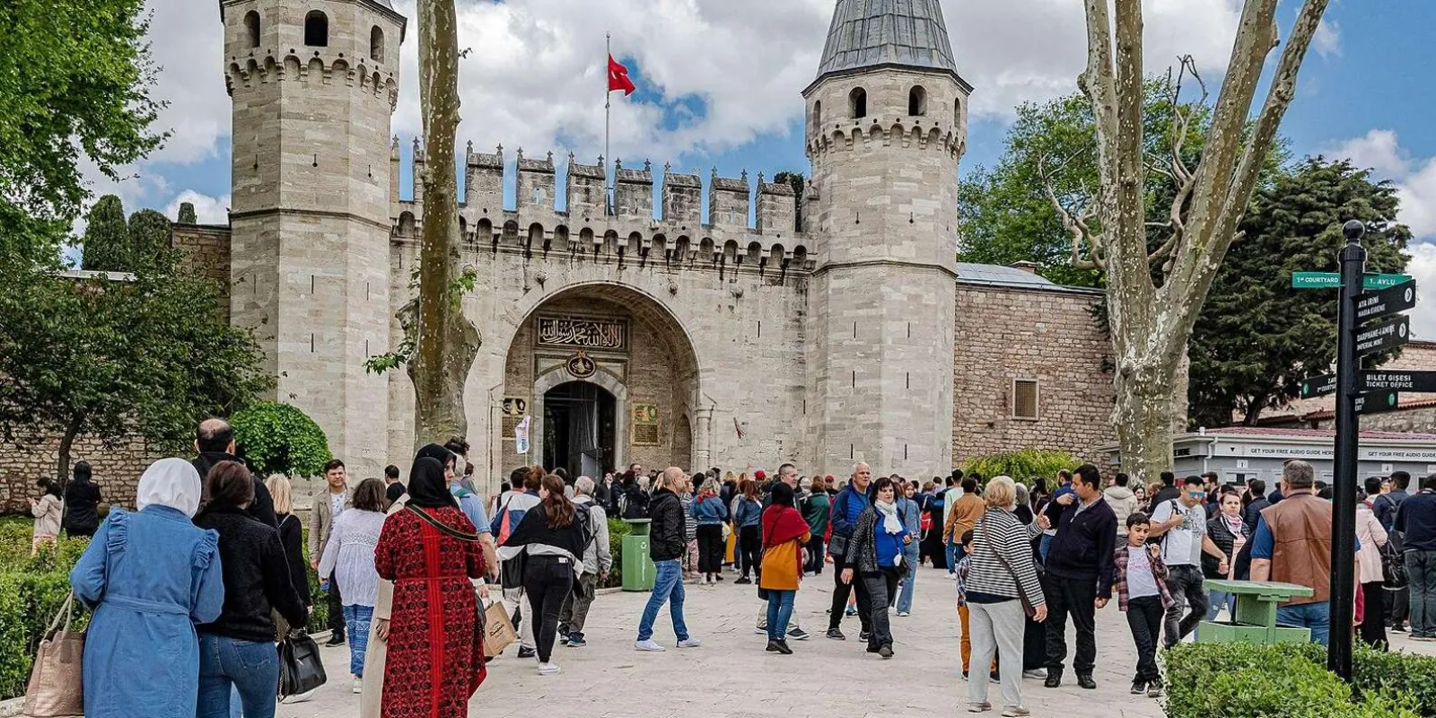 Crowds in the First Court of Topkapi Palace outside the Gate of Salutation, beside the ticket-office signpost