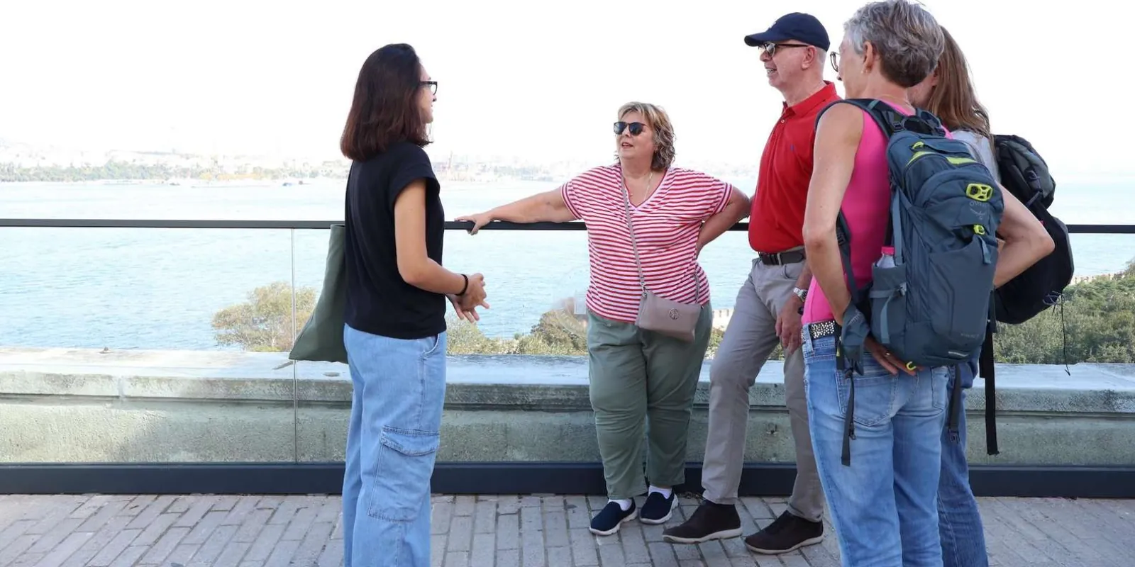 A guide talking to four travellers at a railing above the Bosphorus on the Topkapi Palace terrace