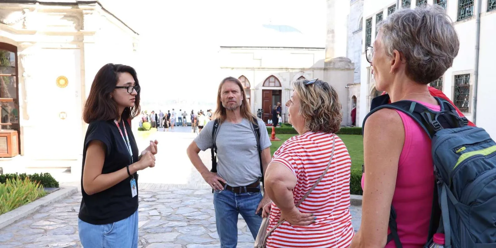 A guide leading a small group across a paved courtyard at Topkapi Palace toward the inner gates